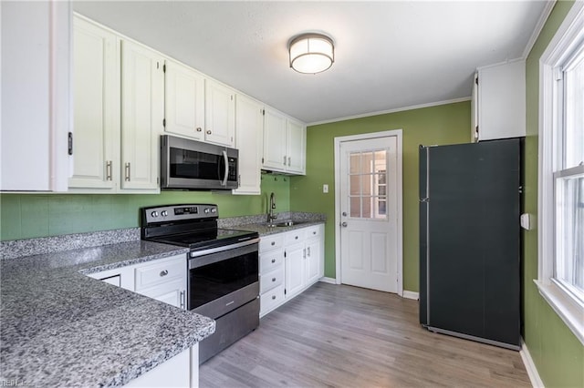 624 Highland Ct, Newport News, VA 23605 - kitchen with appliances with stainless steel finishes, a sink, white cabinets, and healthy amount of natural light