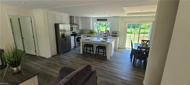 175 Pinto Dr, Moyock, NC 27958 - kitchen featuring stainless steel appliances, wall chimney exhaust hood, white cabinets, a breakfast bar area, and dark wood-style floors