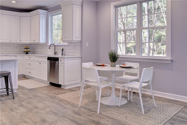 718C Poquoson Ave, Poquoson, VA 23662 - kitchen featuring dishwasher, light countertops, white cabinetry, a sink, and decorative backsplash