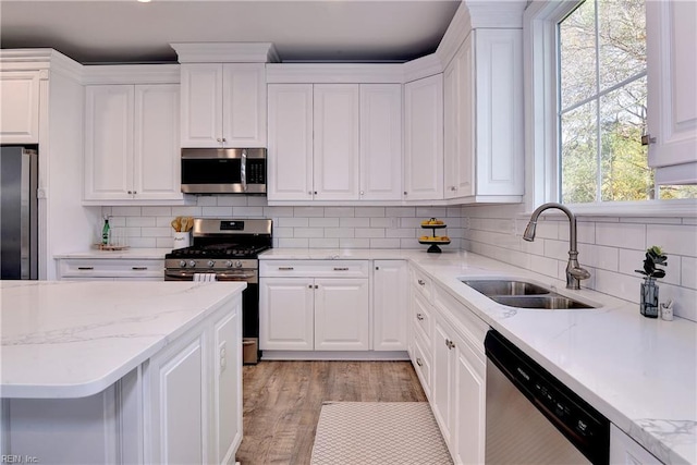 718C Poquoson Ave, Poquoson, VA 23662 - kitchen with stainless steel appliances, a sink, white cabinetry, decorative backsplash, and light stone counters