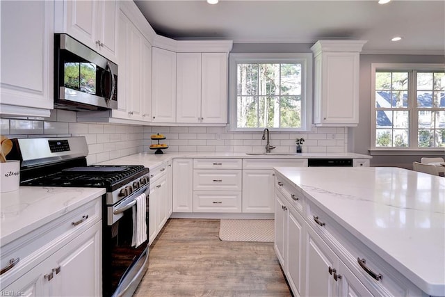 718C Poquoson Ave, Poquoson, VA 23662 - kitchen featuring appliances with stainless steel finishes, a sink, recessed lighting, white cabinetry, and tasteful backsplash