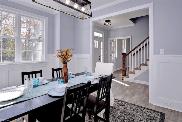 718C Poquoson Ave, Poquoson, VA 23662 - dining room featuring ornamental molding, a decorative wall, a wainscoted wall, stairs, and wood finished floors