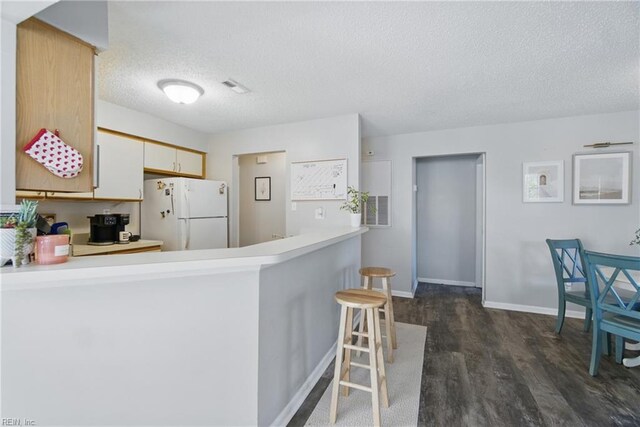 5165 Thatcher Way, Virginia Beach, VA 23456 - kitchen featuring freestanding refrigerator, a textured ceiling, a peninsula, dark wood-type flooring, and light countertops