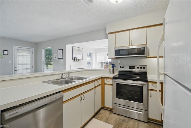 5165 Thatcher Way, Virginia Beach, VA 23456 - kitchen with appliances with stainless steel finishes, a sink, a textured ceiling, light wood-style floors, and light countertops