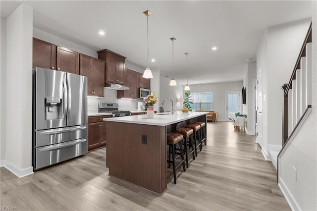 23050 Preserve Pl, Carrollton, VA 23314 - kitchen featuring appliances with stainless steel finishes, light wood finished floors, light countertops, a center island with sink, and recessed lighting