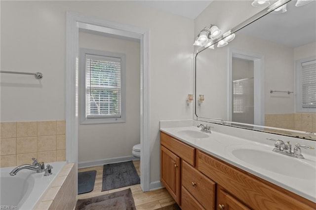 3711 Goodwin Neck Rd, Yorktown, VA 23692 - full bathroom with double vanity, a garden tub, toilet, and baseboards
