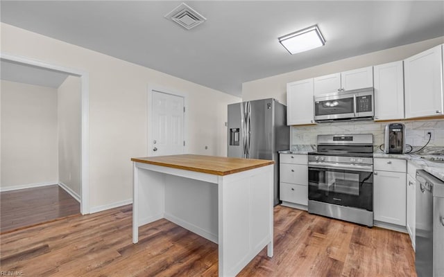 3213 Ashaway Rd, Virginia Beach, VA 23452 - kitchen featuring appliances with stainless steel finishes, butcher block counters, wood finished floors, and decorative backsplash