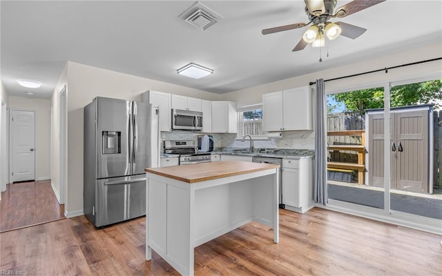 3213 Ashaway Rd, Virginia Beach, VA 23452 - kitchen with appliances with stainless steel finishes, butcher block counters, white cabinets, light wood-style floors, and a center island
