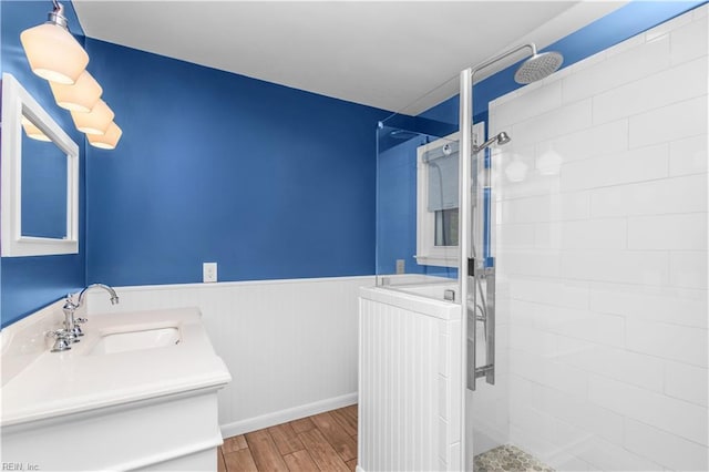 1364 Sir Richard Rd, Virginia Beach, VA 23455 - bathroom featuring vanity, wood finished floors, a tile shower, a wainscoted wall, and baseboards