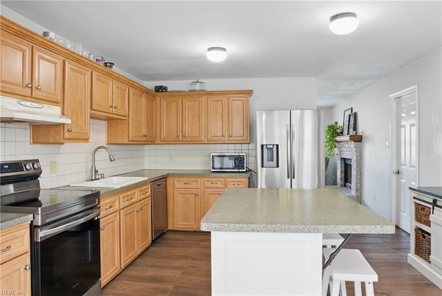 3613 Mostiler Pl, Chesapeake, VA 23323 - kitchen featuring appliances with stainless steel finishes, a sink, a fireplace, under cabinet range hood, and a breakfast bar