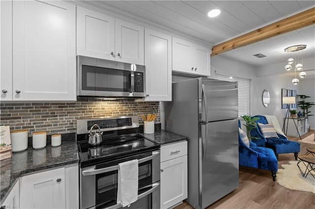 1801 Delaney St, Virginia Beach, VA 23464 - kitchen featuring appliances with stainless steel finishes, white cabinets, light wood-type flooring, decorative backsplash, and dark stone countertops