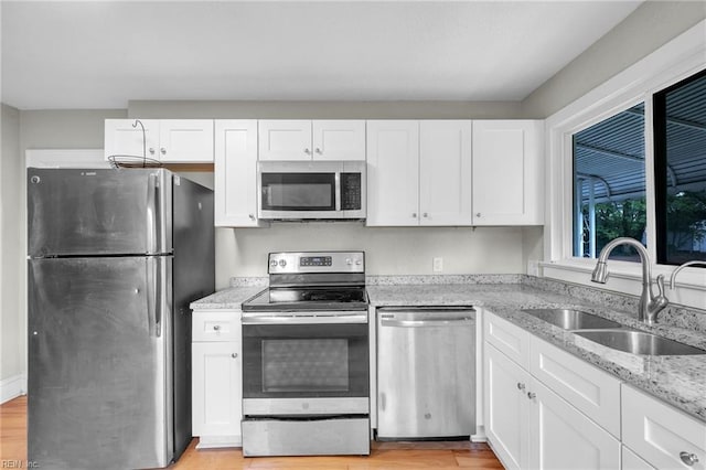 1424 Stewart St, Chesapeake, VA 23324 - kitchen with stainless steel appliances, a sink, white cabinets, and light stone countertops