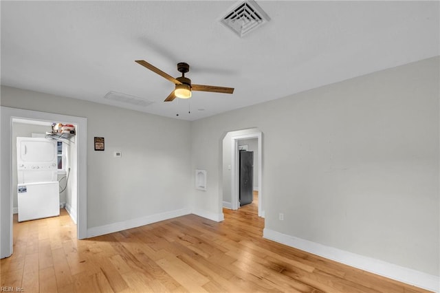 1424 Stewart St, Chesapeake, VA 23324 - spare room with stacked washer / dryer, ceiling fan, light wood finished floors, arched walkways, and baseboards