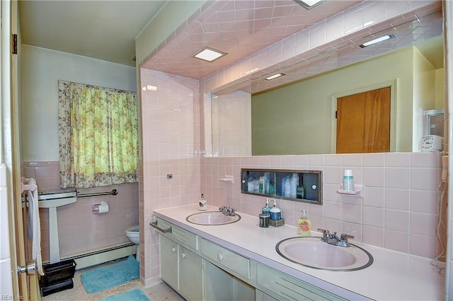 409 Briarfield Dr, Chesapeake, VA 23322 - bathroom with tile walls, a baseboard heating unit, toilet, double vanity, and decorative backsplash