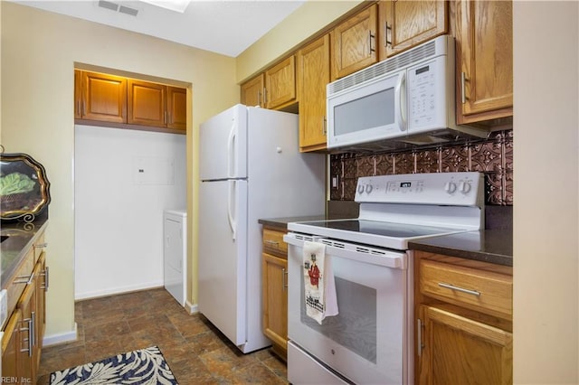 303 Settlement Dr Unit 303, Williamsburg, VA 23188 - kitchen featuring white appliances, dark countertops, brown cabinets, stone finish floors, and washer / clothes dryer