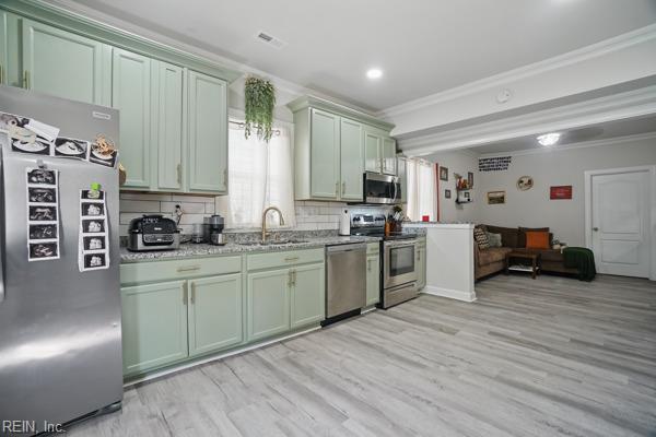 1918 Prentis Ave, Portsmouth, VA 23704 - kitchen with stainless steel appliances, ornamental molding, a sink, light wood-type flooring, and green cabinets