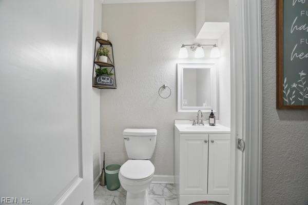 1918 Prentis Ave, Portsmouth, VA 23704 - bathroom featuring marble look tile flooring, toilet, vanity, and a textured wall