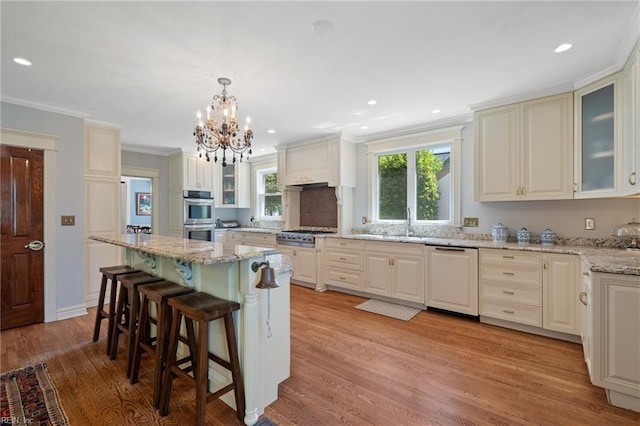 511 Brackenridge Ave, Norfolk, VA 23505 - kitchen with appliances with stainless steel finishes, light wood finished floors, a kitchen breakfast bar, a chandelier, and light stone counters