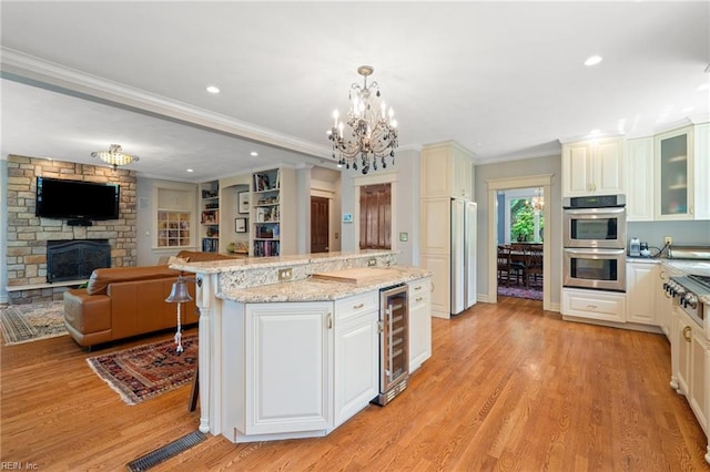 511 Brackenridge Ave, Norfolk, VA 23505 - kitchen featuring beverage cooler, stainless steel appliances, open floor plan, a center island, and light wood finished floors