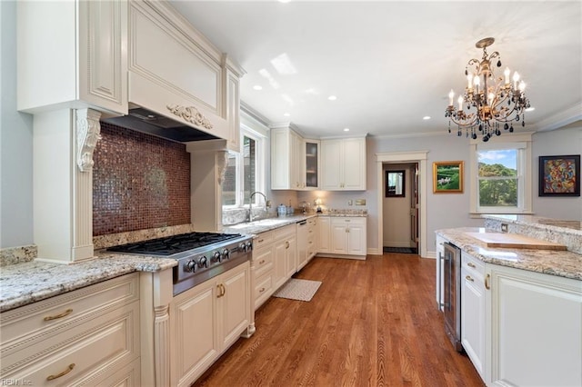 511 Brackenridge Ave, Norfolk, VA 23505 - kitchen with stainless steel gas stovetop, a sink, beverage cooler, backsplash, and light wood-style flooring