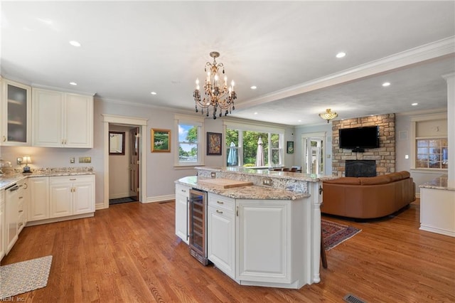 511 Brackenridge Ave, Norfolk, VA 23505 - kitchen featuring beverage cooler, crown molding, a stone fireplace, light wood-type flooring, and white cabinets