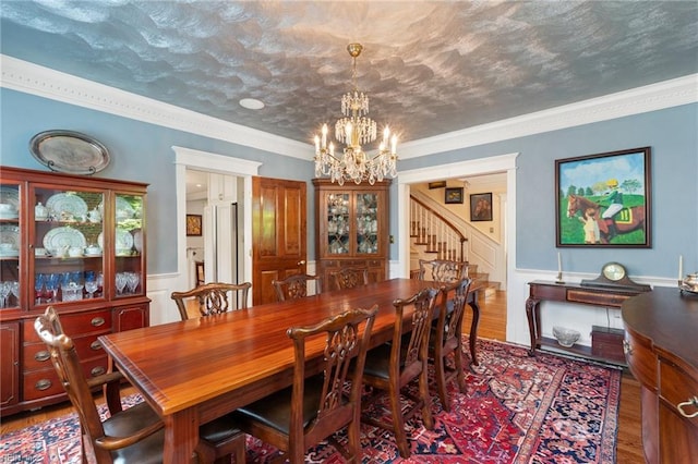 511 Brackenridge Ave, Norfolk, VA 23505 - dining area featuring a chandelier, wood finished floors, a wainscoted wall, crown molding, and stairs