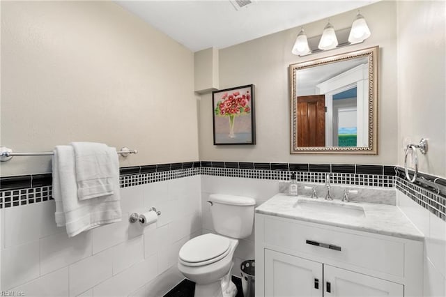 511 Brackenridge Ave, Norfolk, VA 23505 - half bathroom featuring tile walls, vanity, toilet, and a wainscoted wall