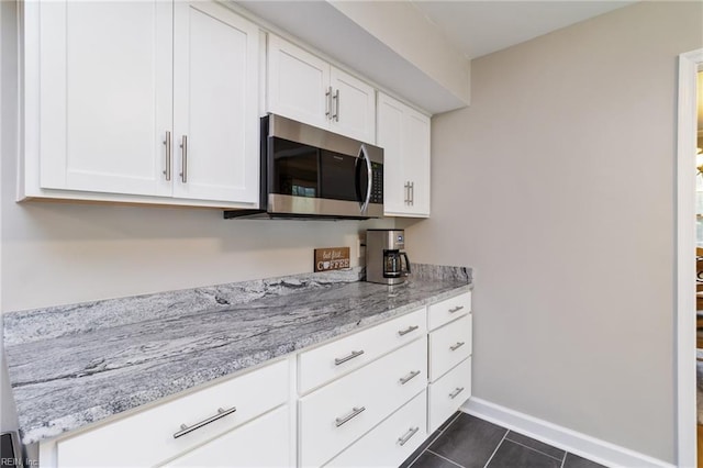 8 Assembly Ct, Newport News, VA 23606 - kitchen featuring stainless steel microwave, white cabinetry, dark tile patterned flooring, and baseboards