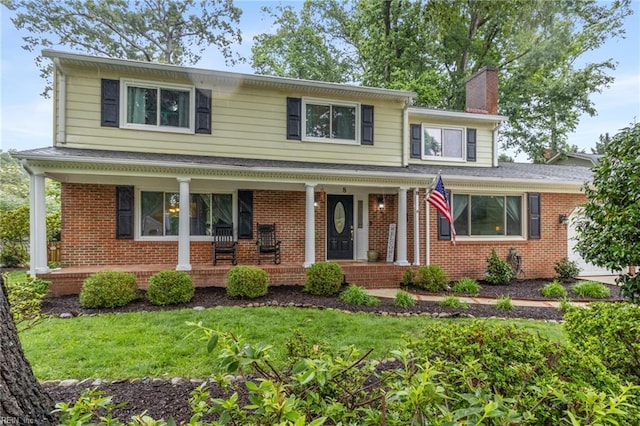 8 Assembly Ct, Newport News, VA 23606 - view of front of house with covered porch, brick siding, a chimney, and a front lawn