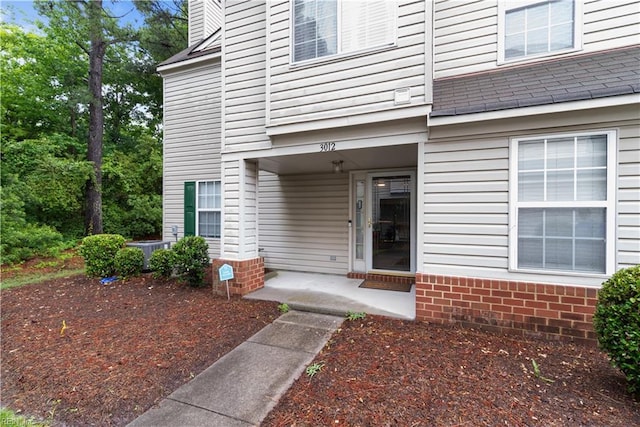 3012 Trappers Run, Chesapeake, VA 23321 - view of exterior entry with roof with shingles, a chimney, and central AC