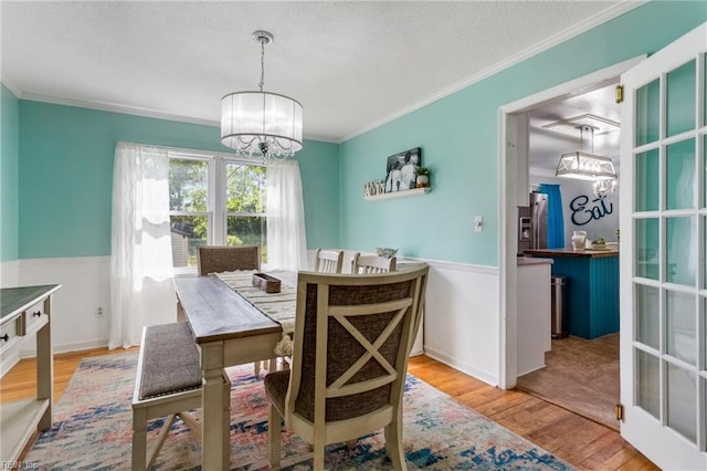 5801 Lancelot Dr, Virginia Beach, VA 23464 - dining room with a chandelier, a wainscoted wall, wood finished floors, crown molding, and a textured ceiling