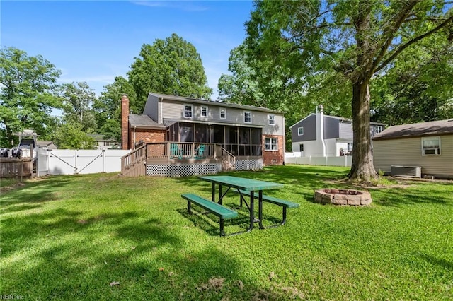 5801 Lancelot Dr, Virginia Beach, VA 23464 - back of property featuring a sunroom, a fire pit, brick siding, and central air condition unit