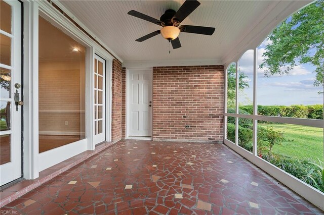 609 River Rd, Newport News, VA 23601 - unfurnished sunroom featuring brick wall, ornamental molding, a ceiling fan, and stone finish floors