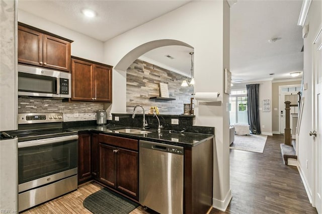 418 Fishers Ct, Hampton, VA 23666 - kitchen featuring appliances with stainless steel finishes, a sink, decorative backsplash, arched walkways, and wood finished floors