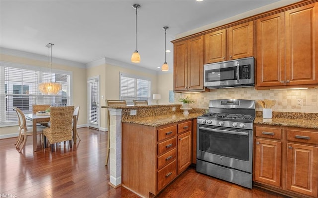 3964 W Stratford Rd, Virginia Beach, VA 23455 - kitchen featuring appliances with stainless steel finishes, brown cabinets, a peninsula, baseboards, and crown molding