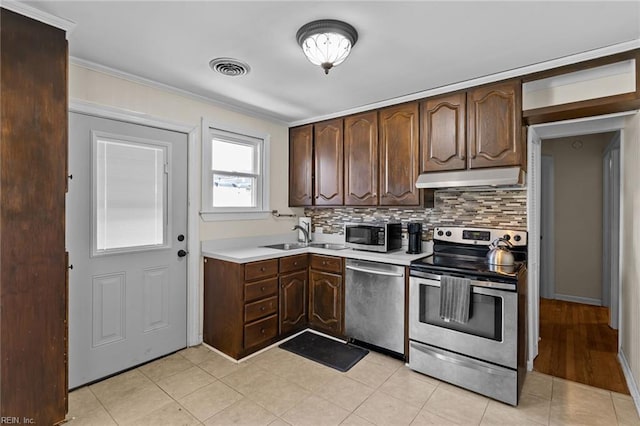 109 Sykes Ave, Portsmouth, VA 23701 - kitchen featuring stainless steel appliances, under cabinet range hood, light countertops, tasteful backsplash, and dark brown cabinets