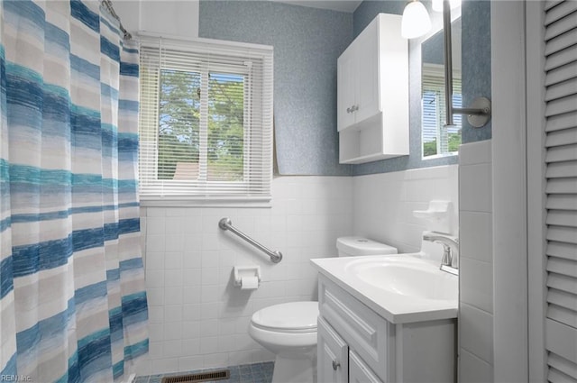 8 Llewellyn St, Portsmouth, VA 23707 - full bath with vanity, toilet, healthy amount of natural light, a wainscoted wall, and tile walls