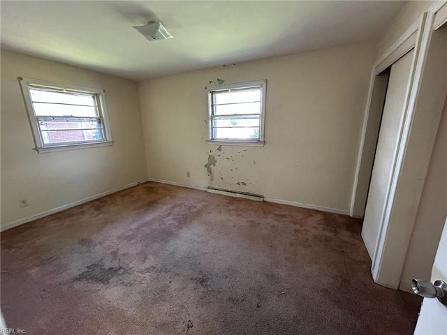1702 Marshall Ave, Newport News, VA 23607 - unfurnished bedroom featuring multiple windows, carpet flooring, a baseboard heating unit, and baseboards