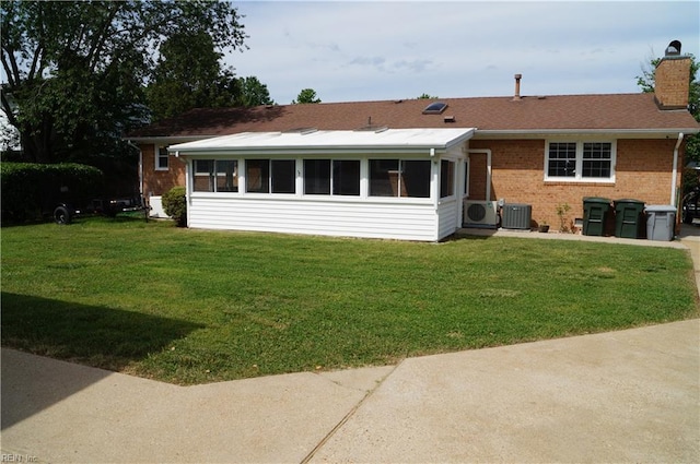 9 Chowning Dr, Hampton, VA 23664 - view of front of home with cooling unit, brick siding, a sunroom, a chimney, and a front yard
