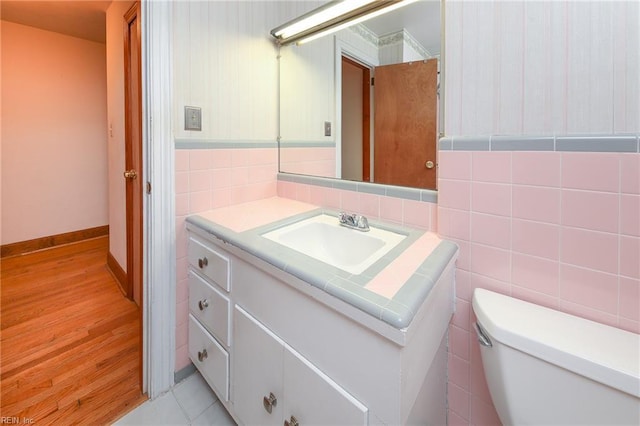 101 Elmhurst Ln, Portsmouth, VA 23701 - bathroom featuring vanity, tile walls, toilet, and wood finished floors