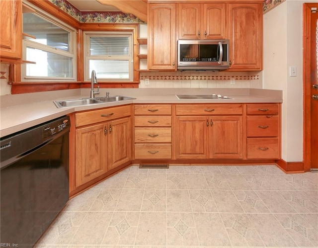 101 Elmhurst Ln, Portsmouth, VA 23701 - kitchen with black appliances, a sink, light countertops, and brown cabinetry