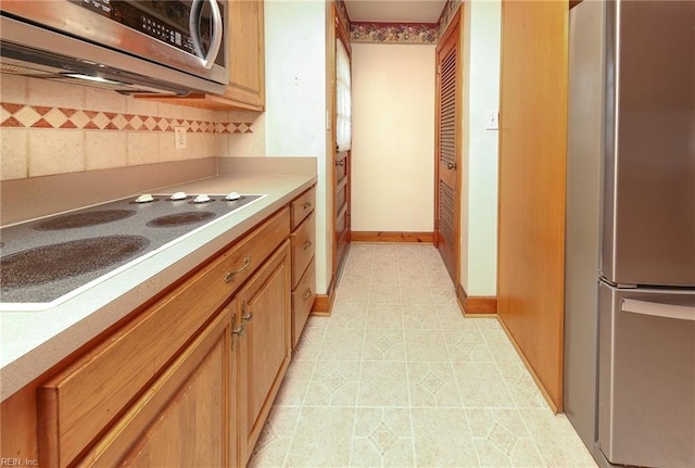 101 Elmhurst Ln, Portsmouth, VA 23701 - kitchen with appliances with stainless steel finishes, tasteful backsplash, light countertops, light tile patterned floors, and baseboards