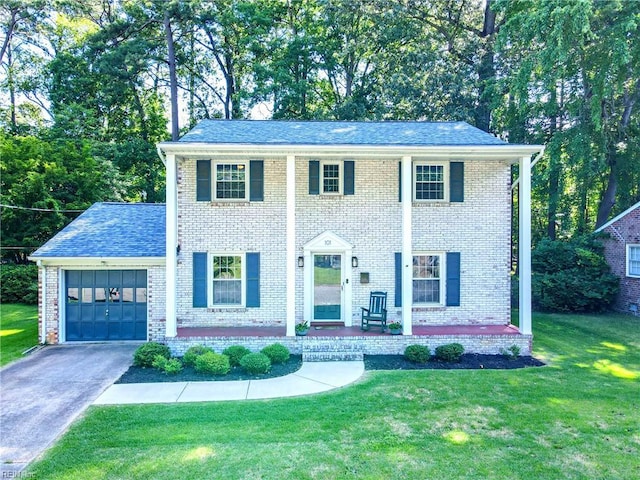 101 Huxley Pl, Newport News, VA 23606 - view of front of home with a garage, a front lawn, brick siding, driveway, and view of wooded area