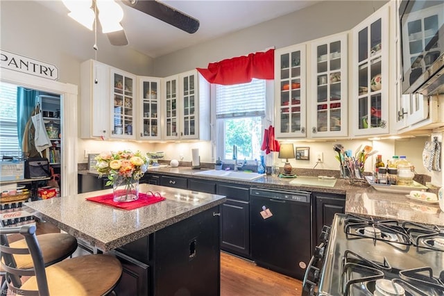 218 Mt Vernon Ave, Portsmouth, VA 23707 - kitchen featuring black dishwasher, a sink, dark cabinets, gas stove, and a breakfast bar area