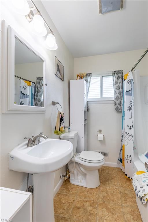 8121 Walters Dr, Norfolk, VA 23518 - bathroom with toilet and shower / bathtub combination with curtain