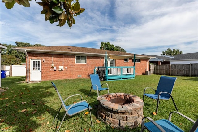 8121 Walters Dr, Norfolk, VA 23518 - rear view of house with an outdoor fire pit, brick siding, a fenced backyard, and a wooden deck
