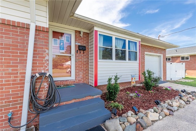 8121 Walters Dr, Norfolk, VA 23518 - doorway to property featuring an attached garage, brick siding, and driveway