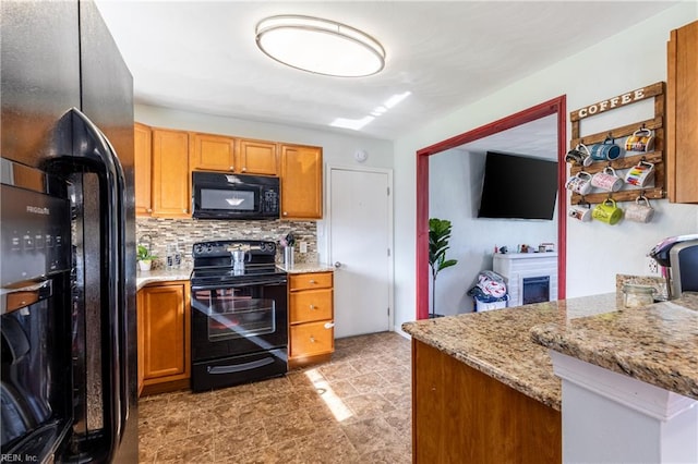 8121 Walters Dr, Norfolk, VA 23518 - kitchen featuring black appliances, tasteful backsplash, light stone countertops, and brown cabinetry
