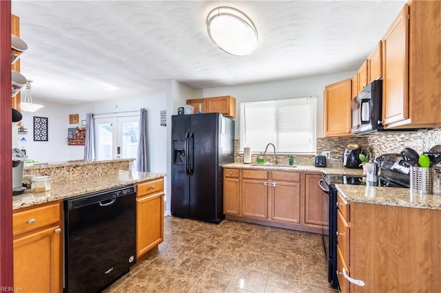 8121 Walters Dr, Norfolk, VA 23518 - kitchen featuring black appliances, light stone countertops, backsplash, and brown cabinetry