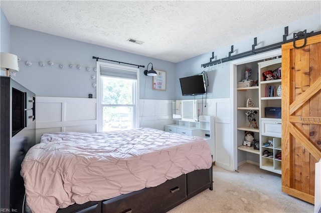 11 Thomas Athey Ct, Hampton, VA 23666 - bedroom featuring a textured ceiling, wainscoting, a barn door, and light colored carpet